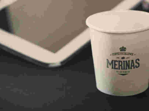 平板电脑旁边的纸杯logo样机